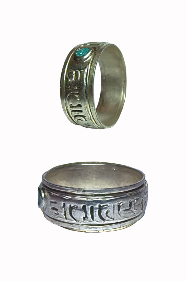 Anillo de alpaca giratorio con mantra en relieve y detalles de color.